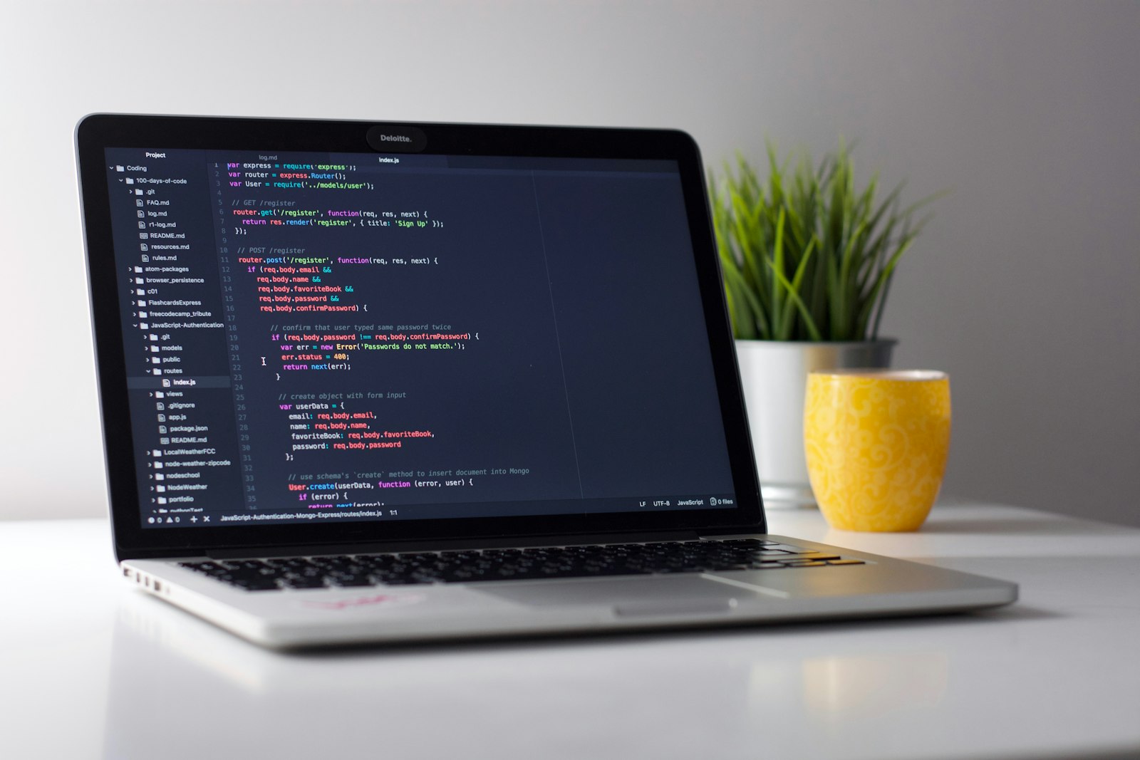 Two people looking at code on a laptop